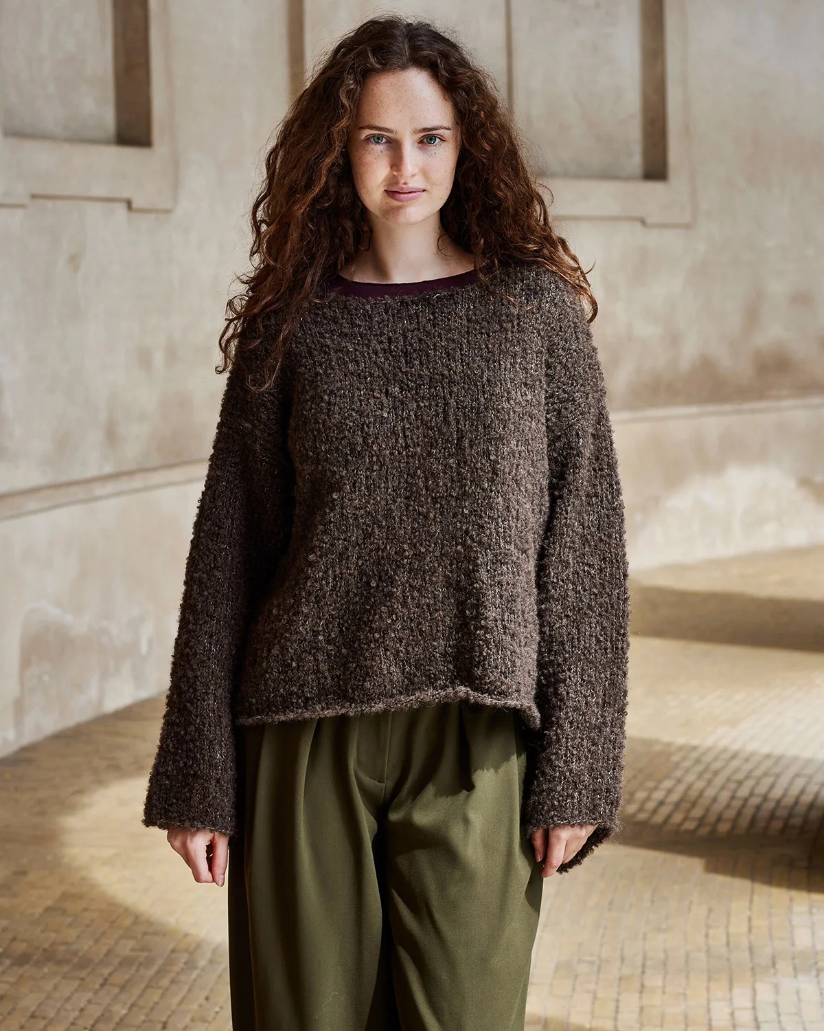 Kvinde i brun oversize sweater strikket i Bodil by Permin