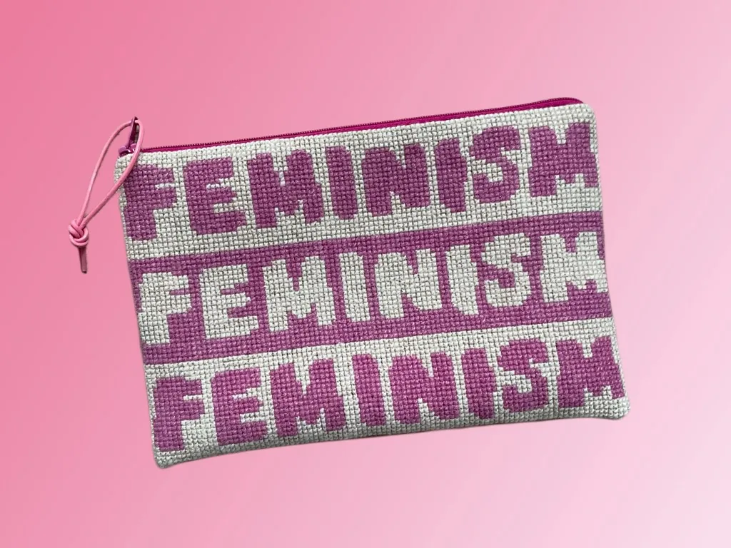 Broderet clutch med ordet FEMINISM gentaget i rosa på lys stramaj, med pink lynlås og lædersnor