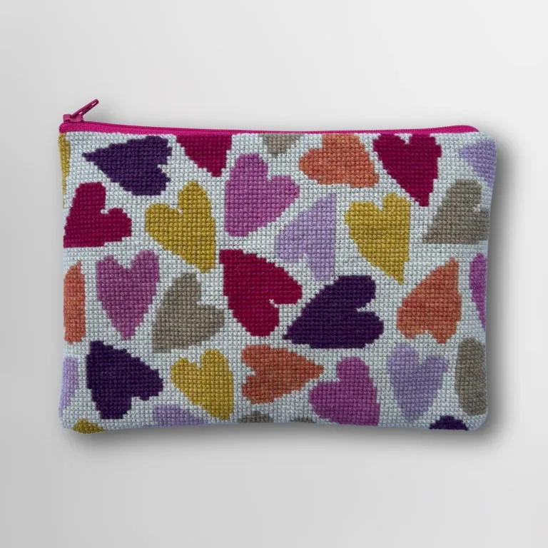 Broderet clutch fyldt med hjerter i pink, lilla, karrygul, orange og naturfarver, med pink lynlås