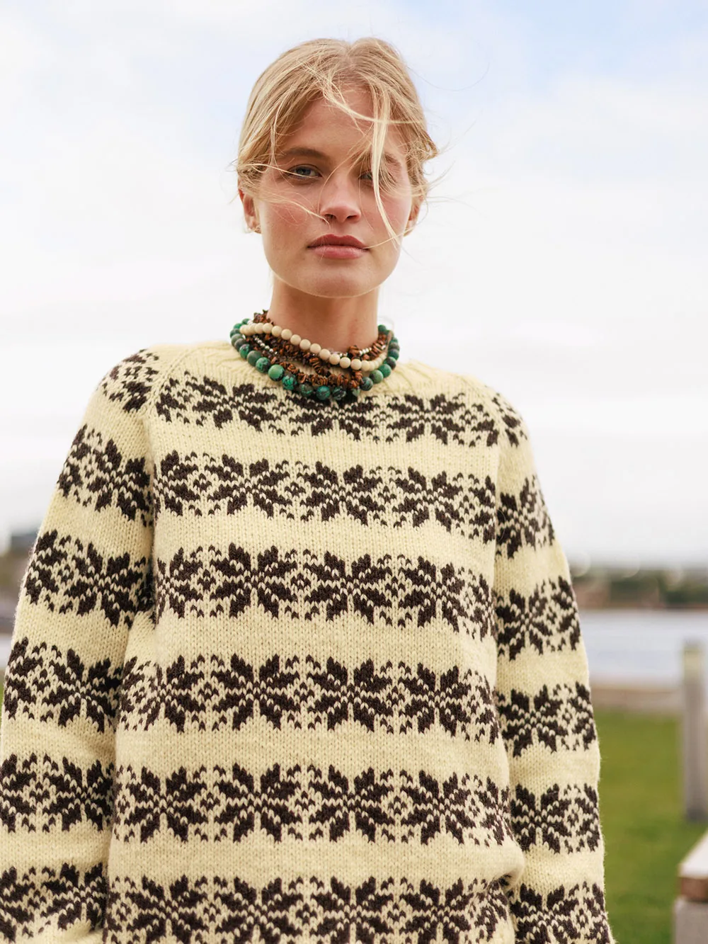 Kvinde i Alvar Dame, mønsterstrikket sweater i Atlas fra Sandnes Garn