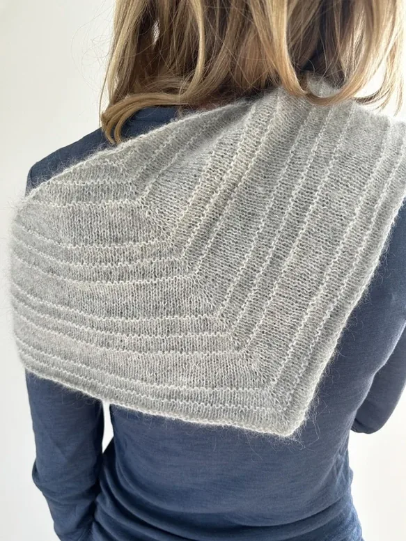 Det store Scala Scarf lagt over skuldrene, set bagfra, med riller langs kanten