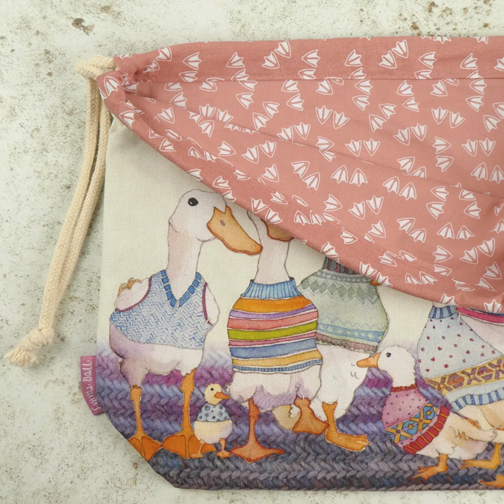 Detalje af Dapper Ducks projekttaske: gammelrosa foer med hvide andefødder og snørelukning